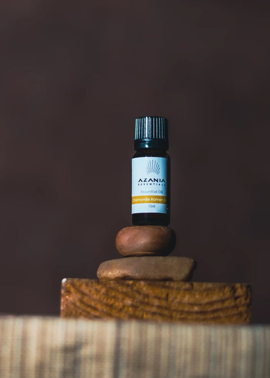 Chamomile Roman Blend Essential Oil on to of two stones and a plank