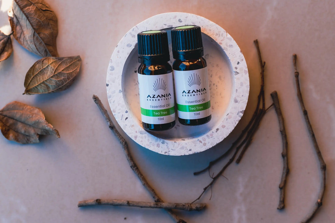 Two Tee Tree essential oils on a table with leaves